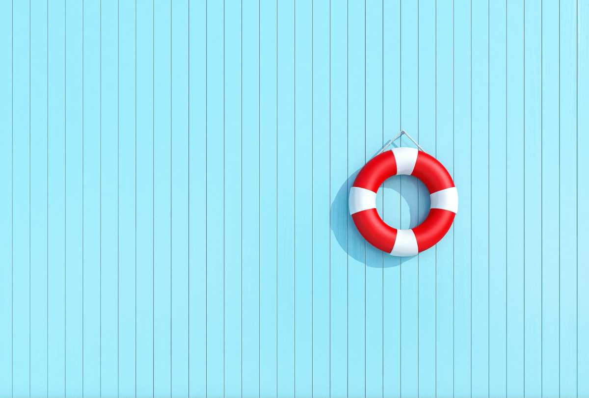 Red lifebuoy in a old grunge wooden plank wall of blue