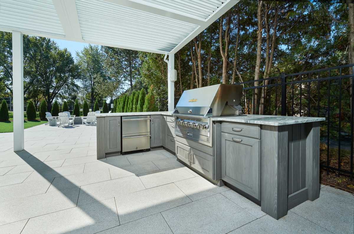 So, you just got home from a midsummer barbecue and pool party at your in-laws, and you were mesmerized by their awesome new outdoor kitchen. Now, the thought of needing one in your own yard simply won’t leave your mind. As the week goes on, at work, you’re constantly thinking about the great parties you’ll host with yours. The beautiful stonework that will enclose the new grill, refrigerator, wine cooler, kegerator, and sink suddenly becomes all that matters. After spending the weekend grilling on your boring standalone grill, having to run back inside to grab everything, that’s it, you decide you need a new outdoor kitchen like you need air. 