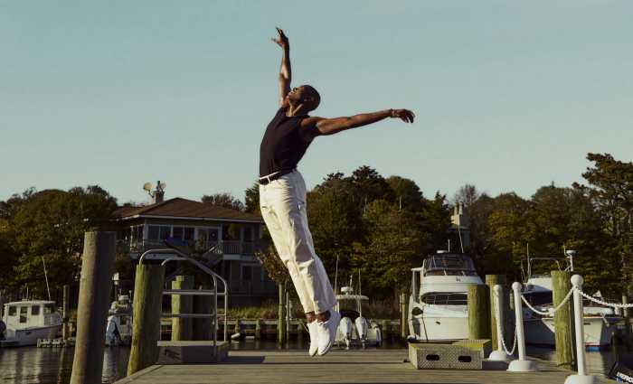 The Fire Island Dance Festival, returning July 18-19 to Fire Island Pines, is set on a waterfront stage overlooking the Great South Bay. The festival gathers extraordinary dancers in a place where salt air, open sky, and communal memory become part of the performance. Here, dance is not merely entertainment. It is witness, offering, and love made visible, moving from the stage into real life through meals, medication, counseling, emergency assistance, testing, grants, and care.